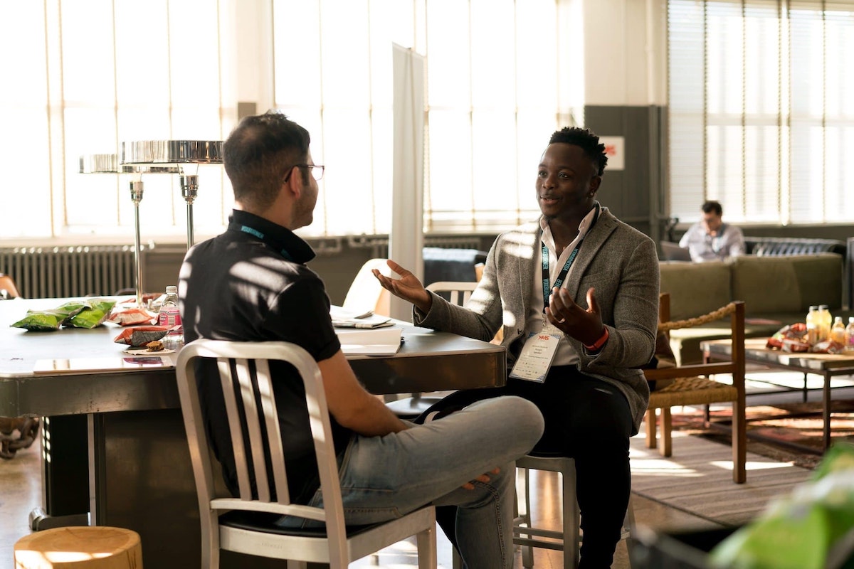 Coffee Shop - two men talking sitting at a table.