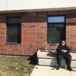 Doroca, tenant sitting in front of her building, North End Landing, Hamilton